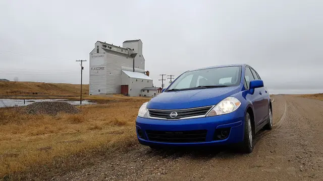 Grain elevator at Flaxcombe with a blue car on the gravel road